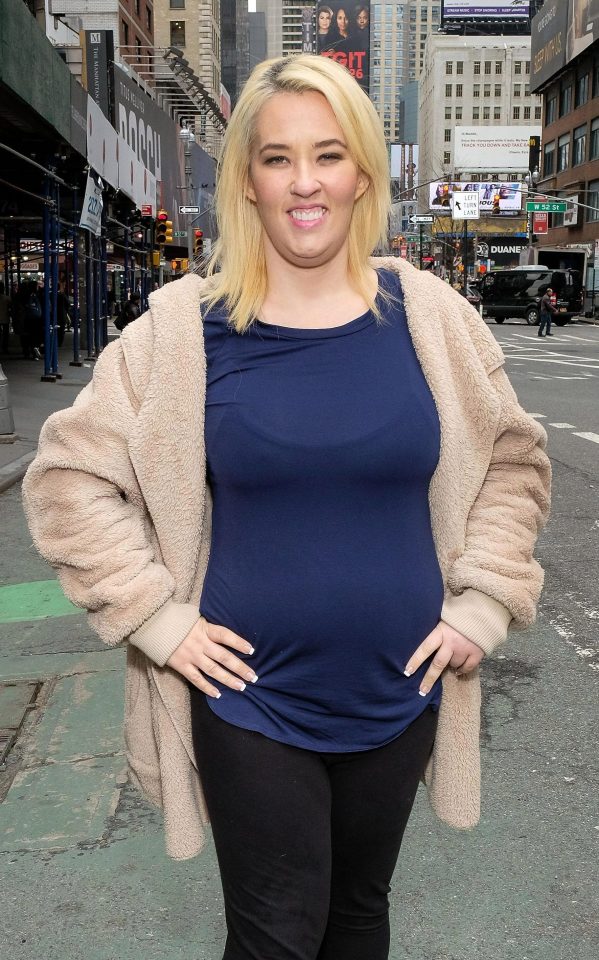  The reality star, 37, looked delighted as she threw open her coat and displayed her new flat stomach in a navy top while posing for photos