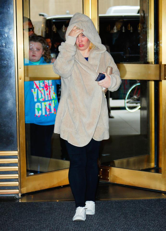  It looked like she was trying to keep a low profile inside the skyscraper as she pulled her coat shut and wore her hood up