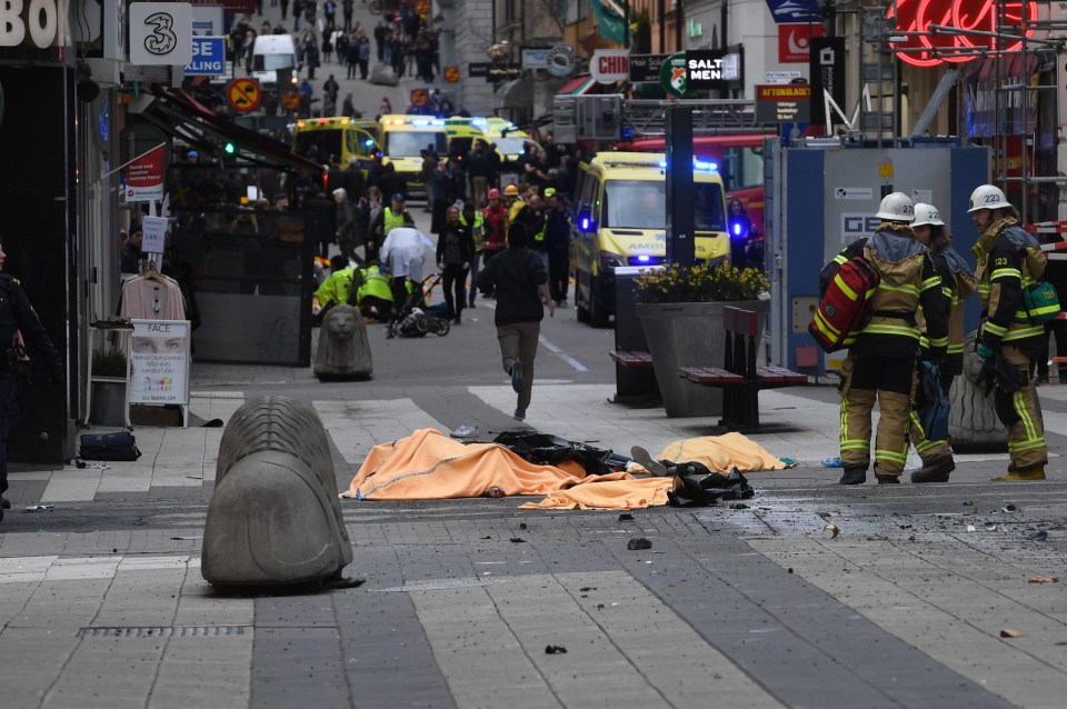 Orange blankets have been laid over the bodies of the dead