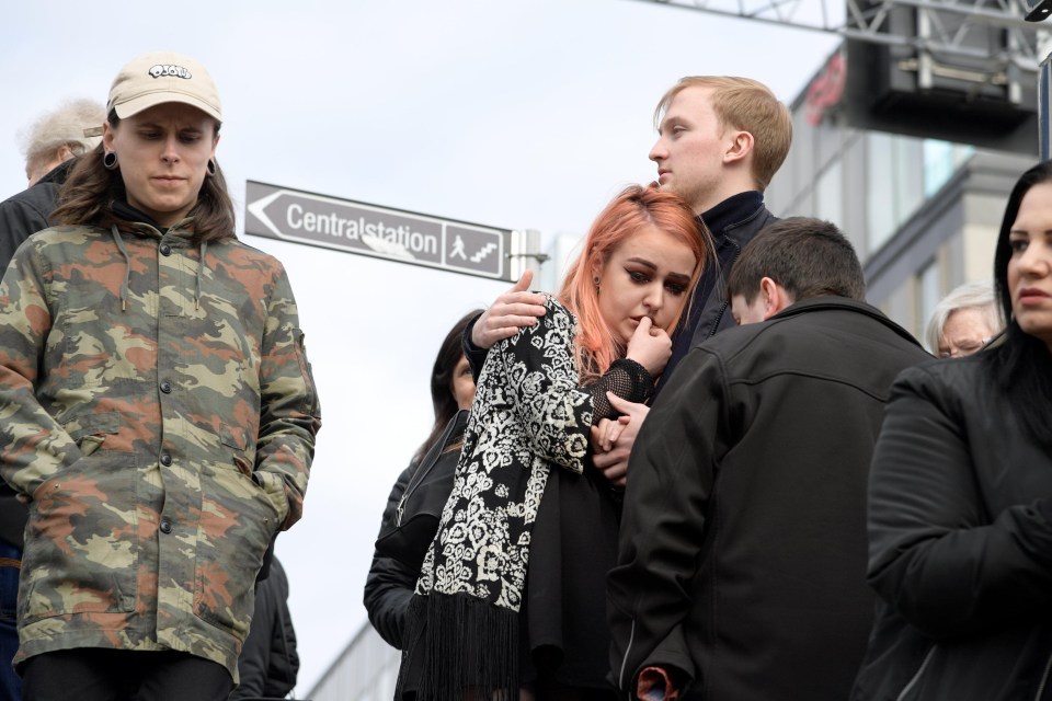 A girl is comforted outside the Ahlens mall in Stockholm