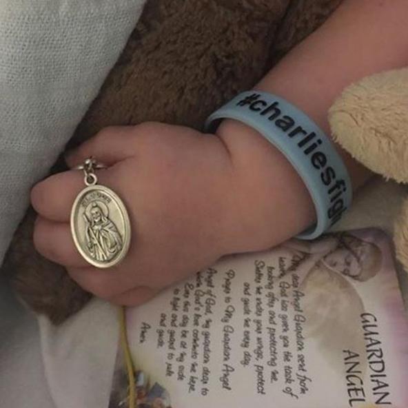  The couple released a picture of Charlie clutching a medallion of St Jude - the patron saint of 'lost causes'