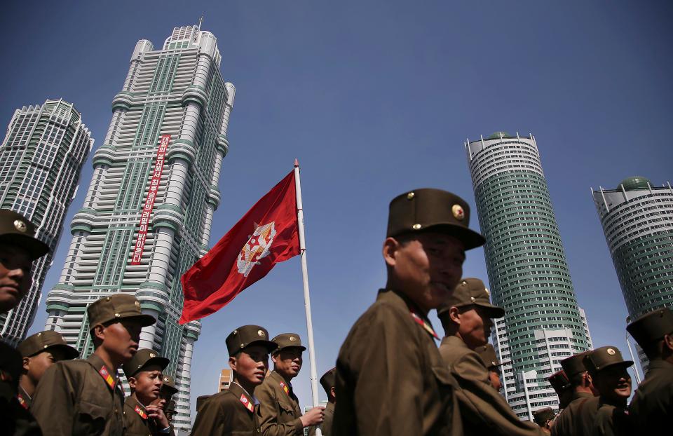  North Korean soldiers march past tower blocks opened by Kim Jong-un