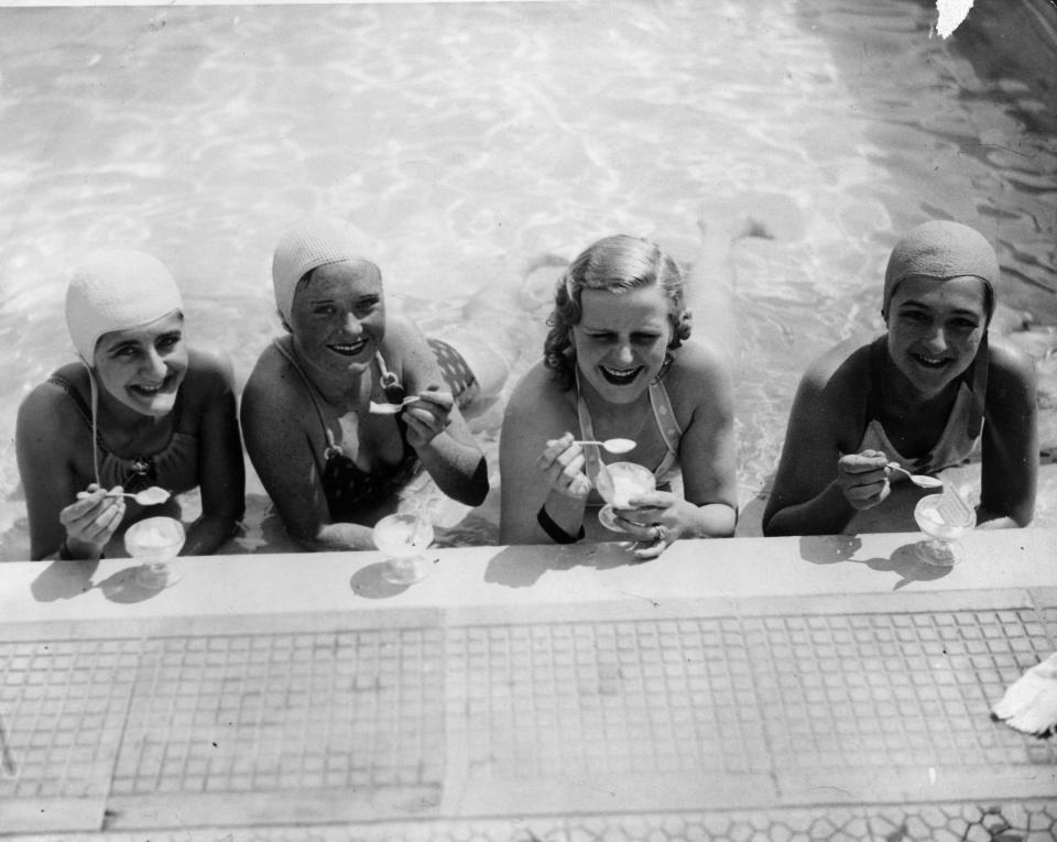  Four swimmers enjoy an ice-cream at the water's edge in Roehampton swimming pool in 1936