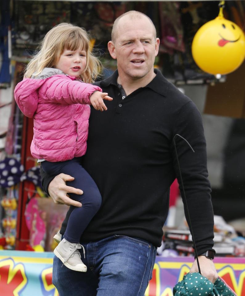 The three-year-old daughter of Zara, 35, and Mike Tindall, 38, was seen happily playing on a bouncy castle and later being carried by her dad