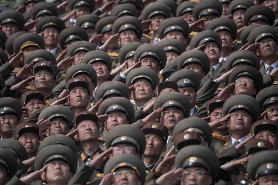  Korean People's Army troops salute as they watch the military parade