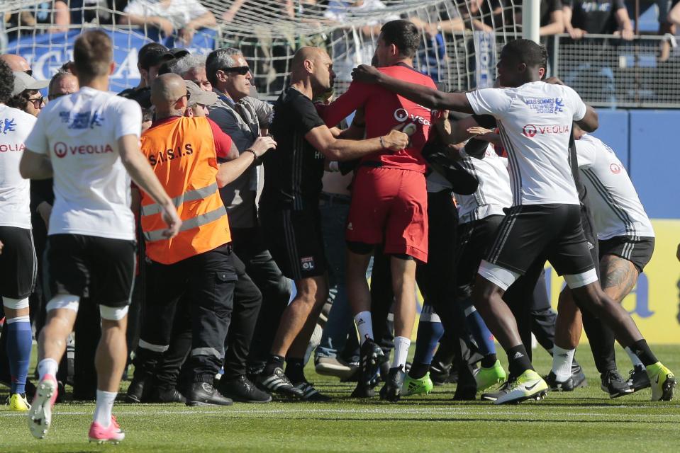  Lyon's goalkeeper kicks out as Bastia fans invade the pitch