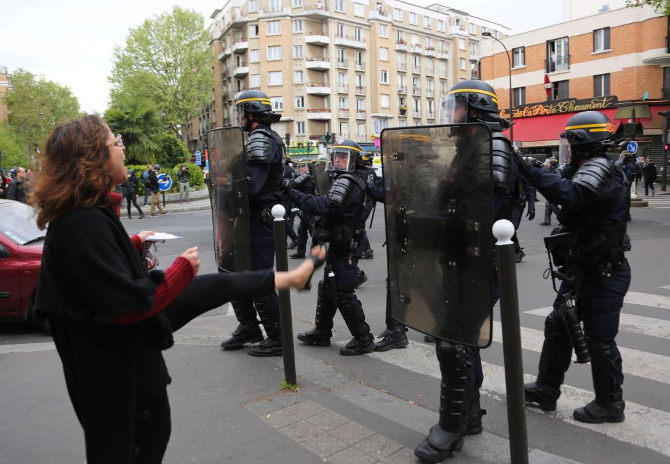  A woman appears to kick out at cops in riot gear policing the protest this afternoon