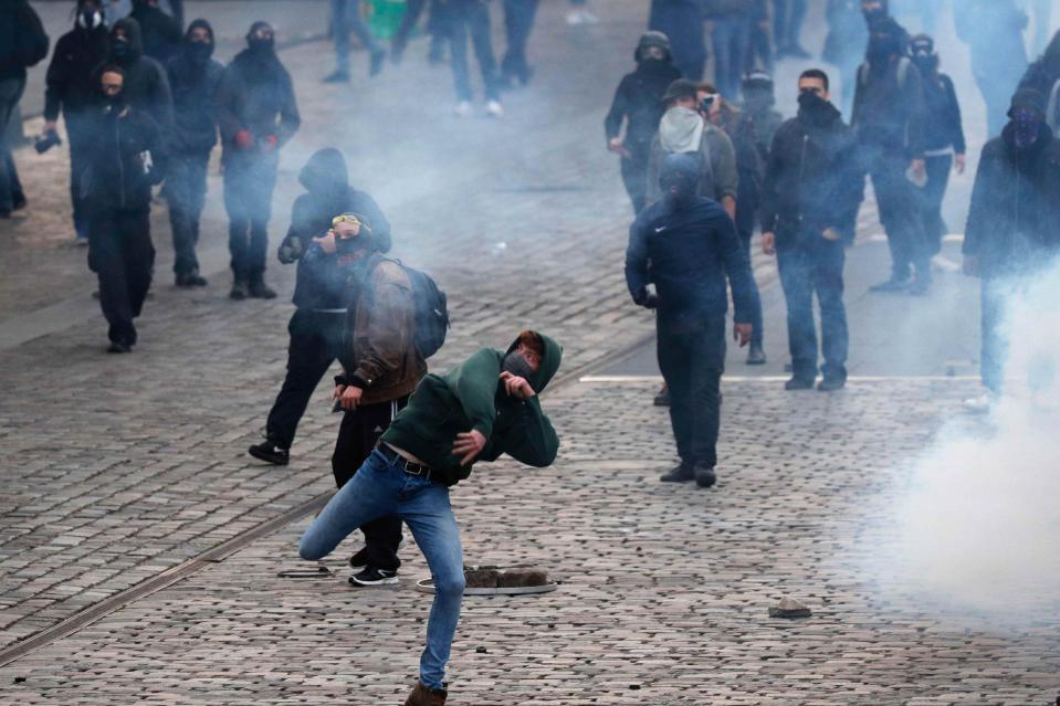  Protesters hurl missiles at riot police in Paris this afternoon