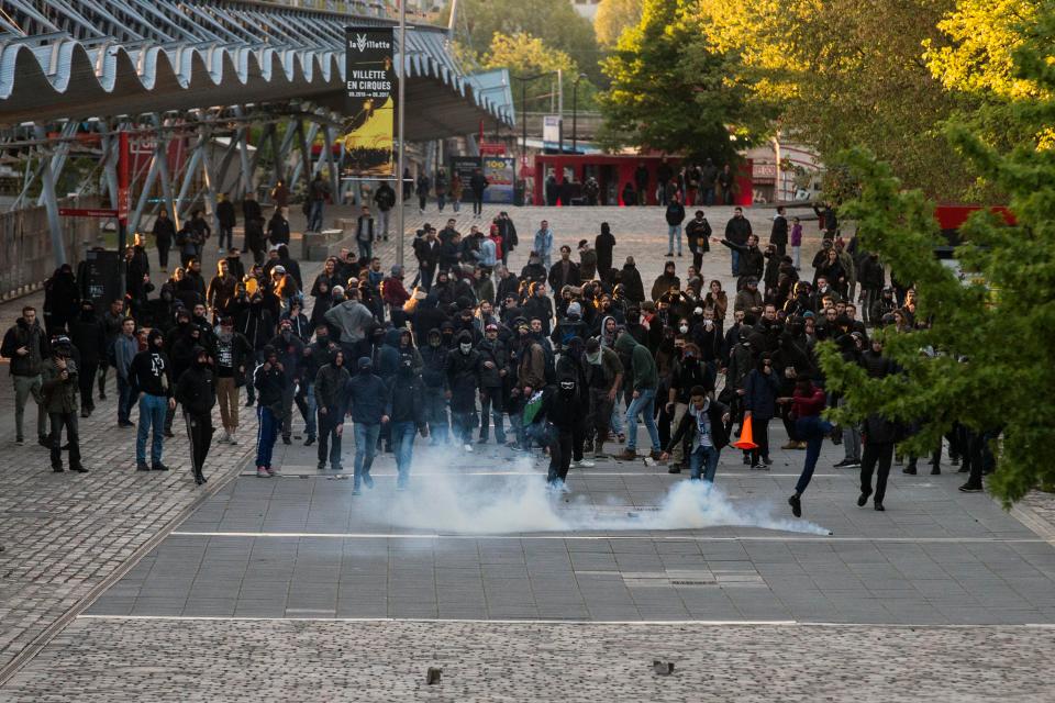  Crowds of demonstrators approach police down the road in northern Paris