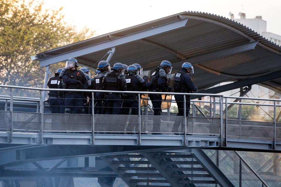  Cops huddle together behind their shields as they are pelted with missiles