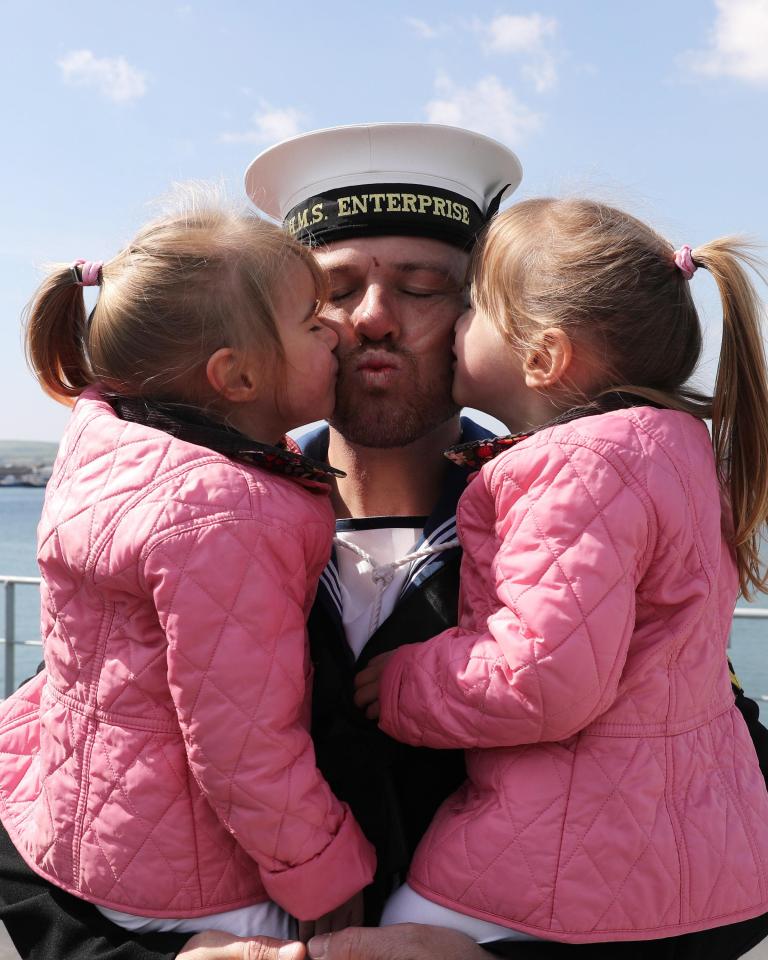  LH Dixon Payne sweeps up his twin daughters Summer and Amelia for a long-awaited cuddle after returning home after three years at sea