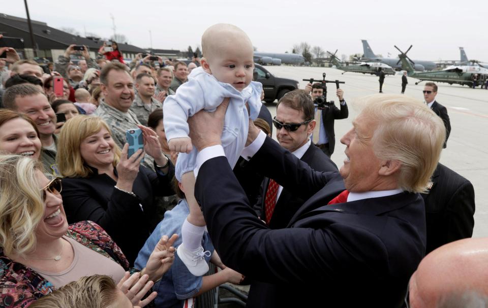 Trump does the classic holding a baby shot which seems to be compulsory for every American politician