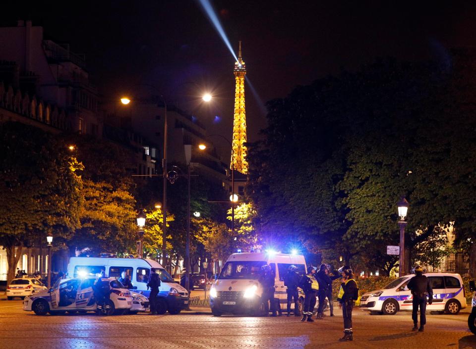  The Eiffel Tower is seen behind police cars as cops hunt the area