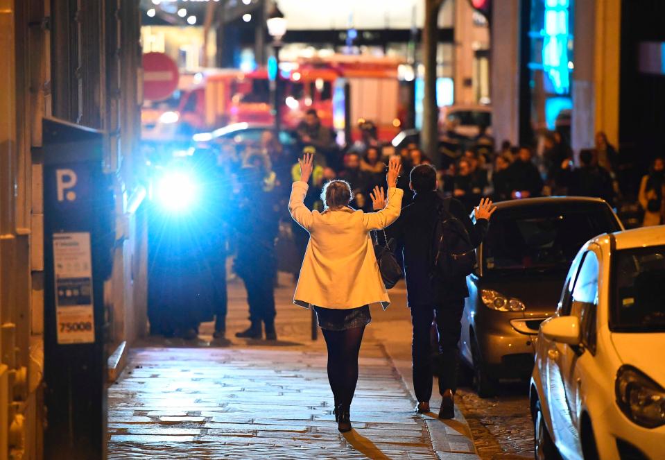  Women raise their arms as they head towards armed police