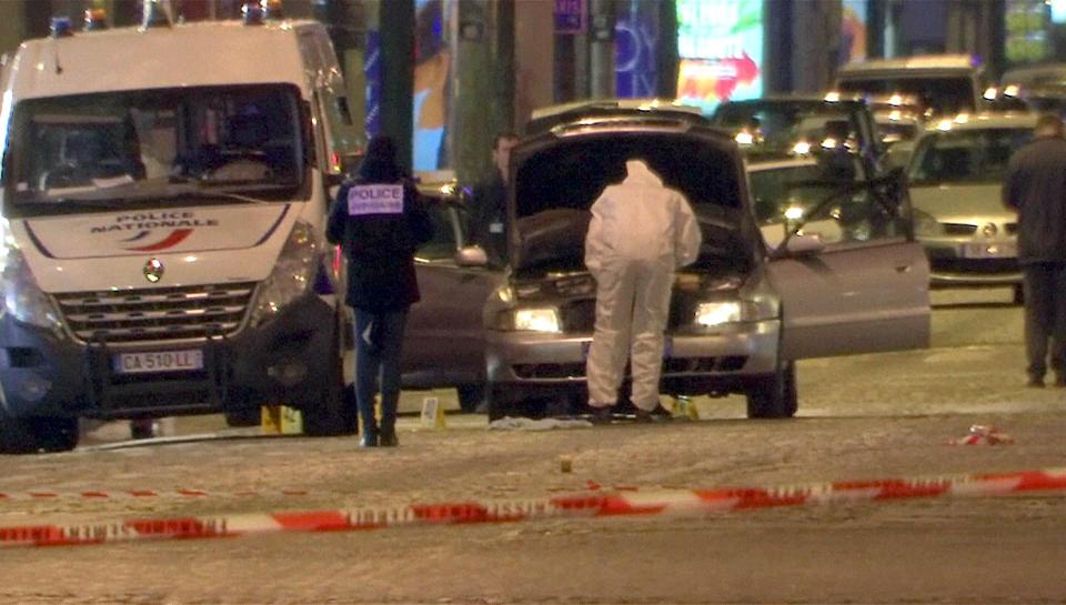  Forensics officers search a grey Audi thought to have been driven by the assailant