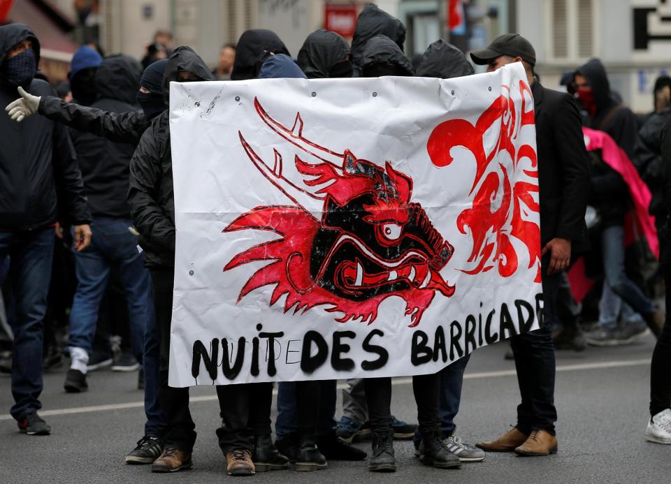  Masked demontrators hold a banner that reads "the night of barricades" as they take part in the protest march