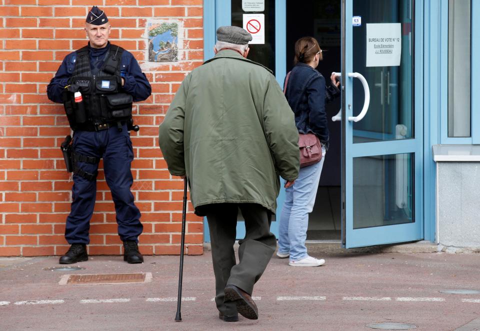  A French police officer secures a polling station as voters start to arrive for the first round of the 2017 French Presidential Election