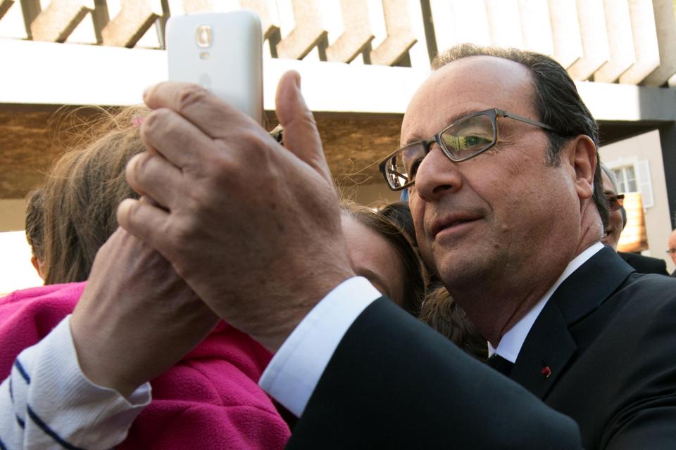  Current French President Francois Hollande takes a selfie with a supporter after voting in Tulle, central France