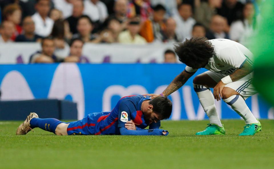 Lionel Messi lies on the ground after being caught be Marcelo's elbow during El Clasico