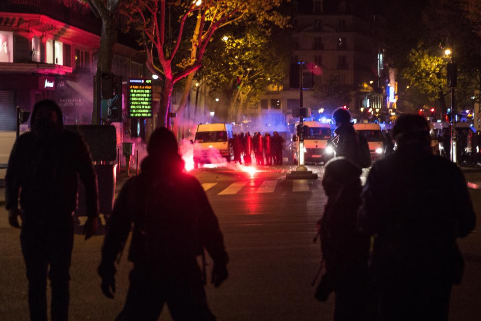  Far left protesters light a flare while clashing with police