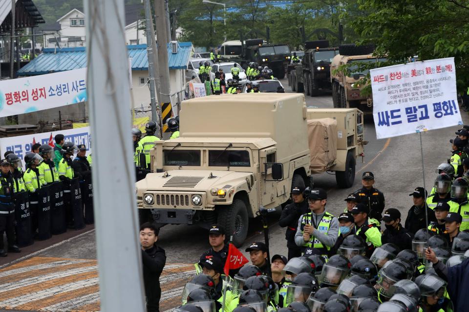  Anti-war protesters and police stand by as trailers carrying US THAAD missile defence equipment enter a deployment site in Seongju this morning