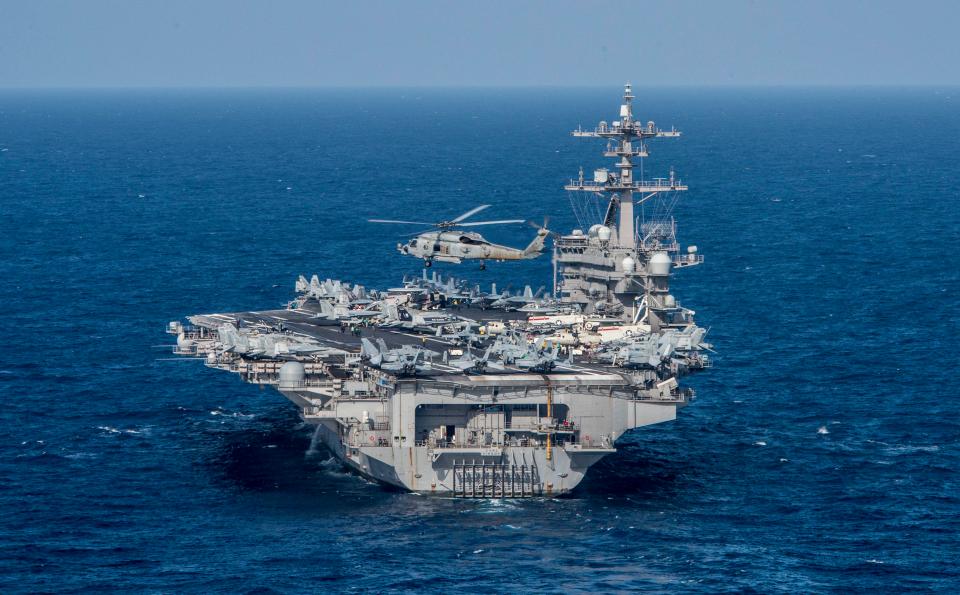  MH-60R Sea Hawk from the Helicopter Maritime Strike Squadron (HSM) 78 'Blue Hawks' flies near the aircraft carrier USS Carl Vinson (CVN 70) at sea in the Philippine Sea