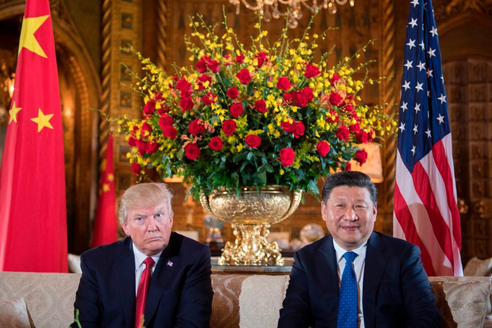 President Donald Trump and Chinese President Xi Jinping pause for photographs at Mar-a-Lago, Friday, April 7