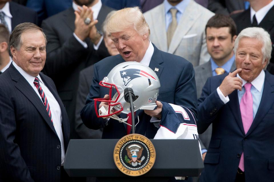 New England Patriots Head Coach Bill Belichick, left, and team owner Robert Kraft, right, present a football helmet to US President Donald Trump during a celebration of the team's Super Bowl victory