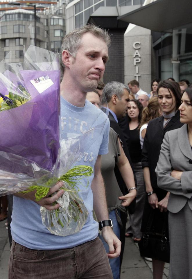  A tearful Mr Dadge holds flowers as he arrives at Edgware station to pay his respects