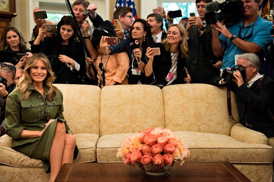 Melania Trump appears uncomfortable as the cameras close in while she is sitting alone on a sofa in the Oval Office