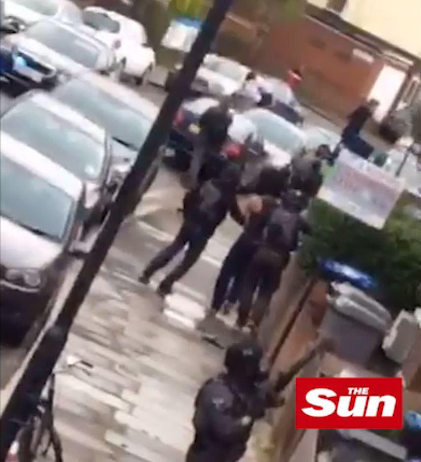  Another suspect can be seen in a vest as he is surrounded by armed cops 