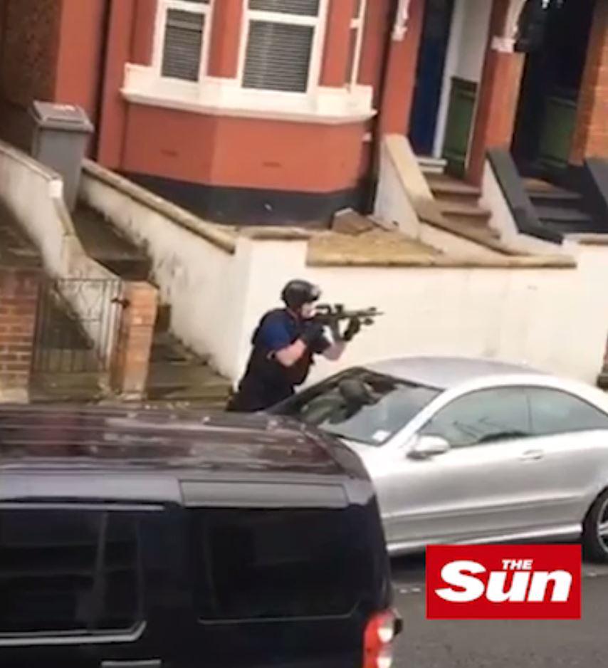  An armed officer can be seen pointing his gun at the suspected woman terrorist from across the street