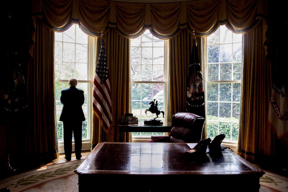 In this photo taken April 21, 2017, President Donald Trump looks out an Oval Office window at the White House