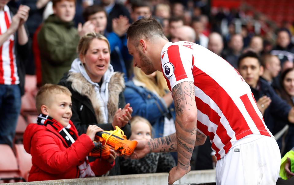  Marko Arnautovic gifts his boots to a lucky fan after the game