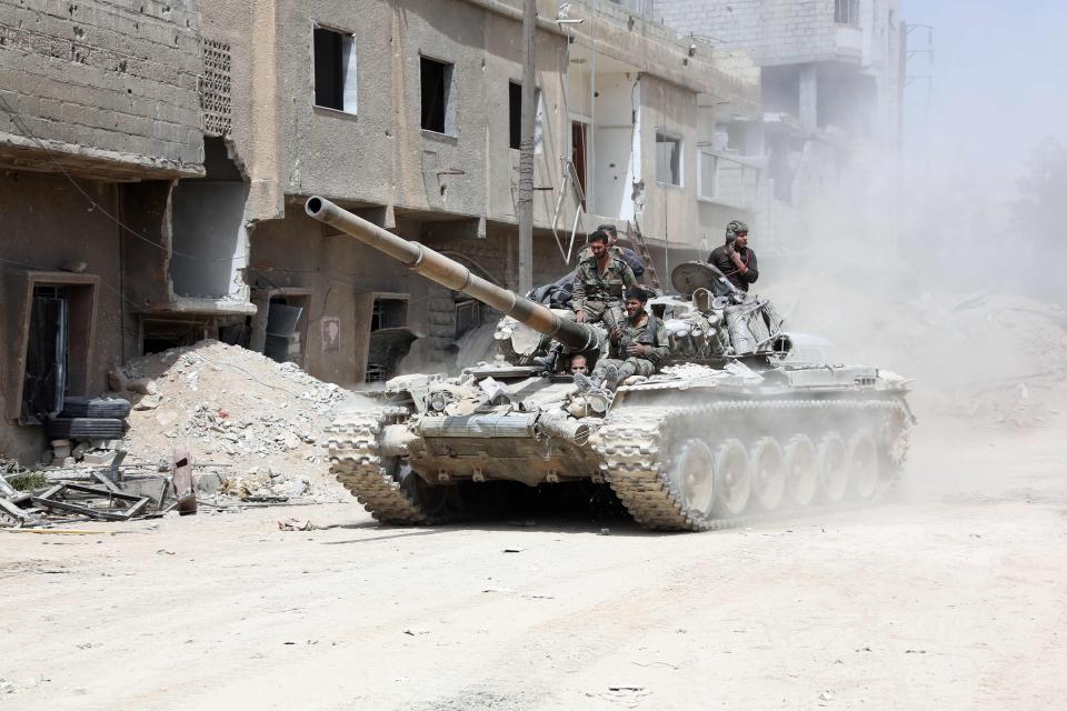  Syrian Army soldiers advancing in an area on the eastern outskirts of Douma