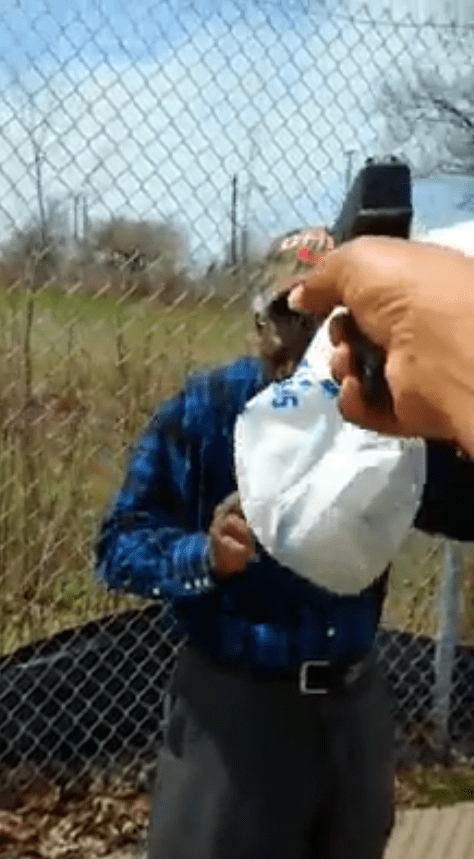  The suspect is then shown holding the gun to Mr Godwin's head before pulling the trigger