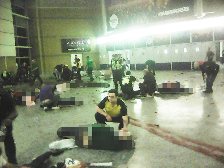 Helpers attend to people inside the Manchester Arena after a suicide bomber detonated an explosive device