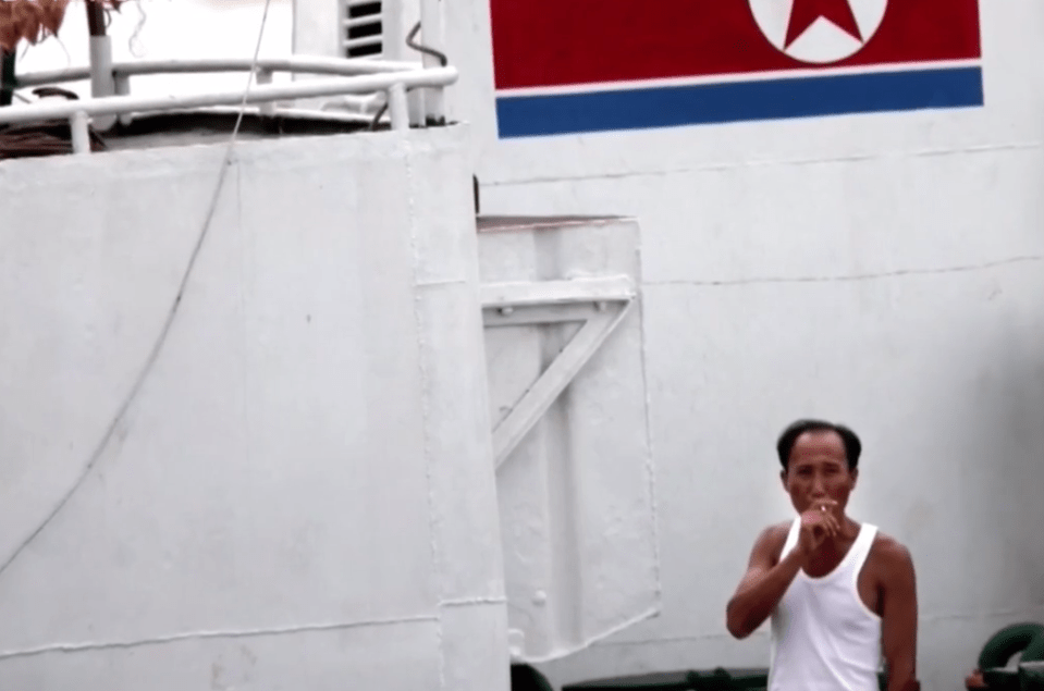  A North Korean fisherman smokes a cigarette on his vessel