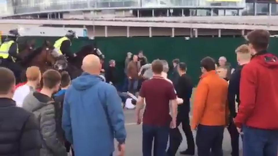  The two police officers on horseback struggled to separate the two rival sets of fans