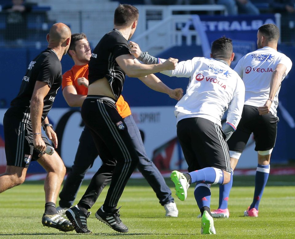  A Bastia supporter fights with Lyon players during the warm-up