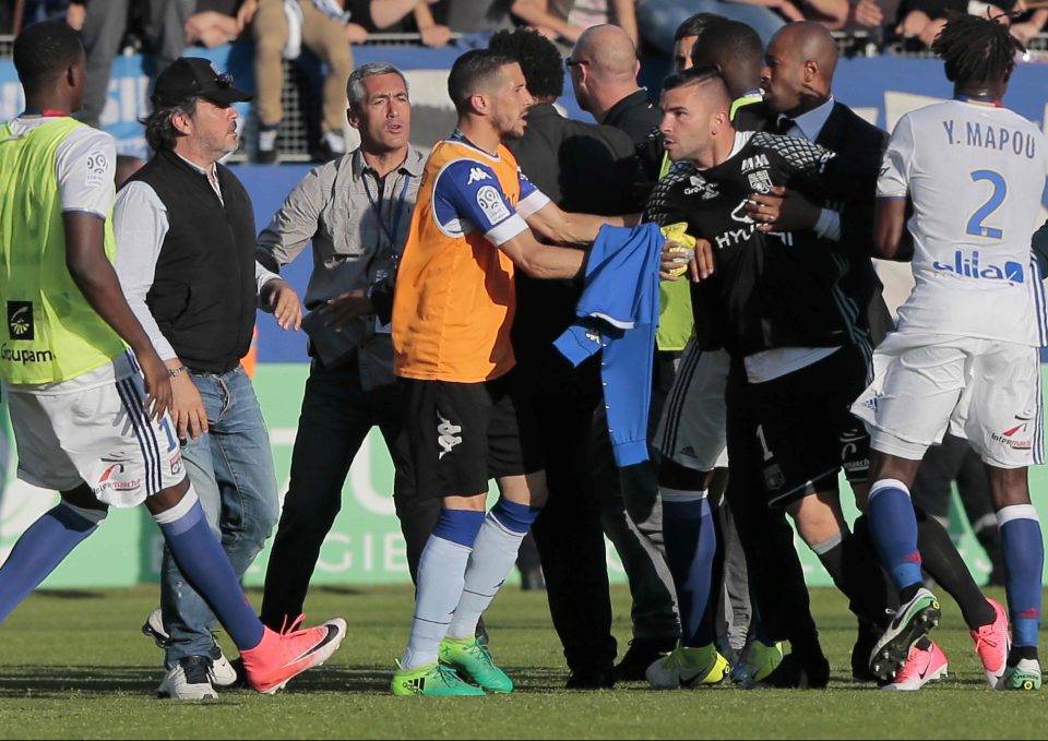  Lyon's Anthony Lopes is held by security staff as Bastia fans move in