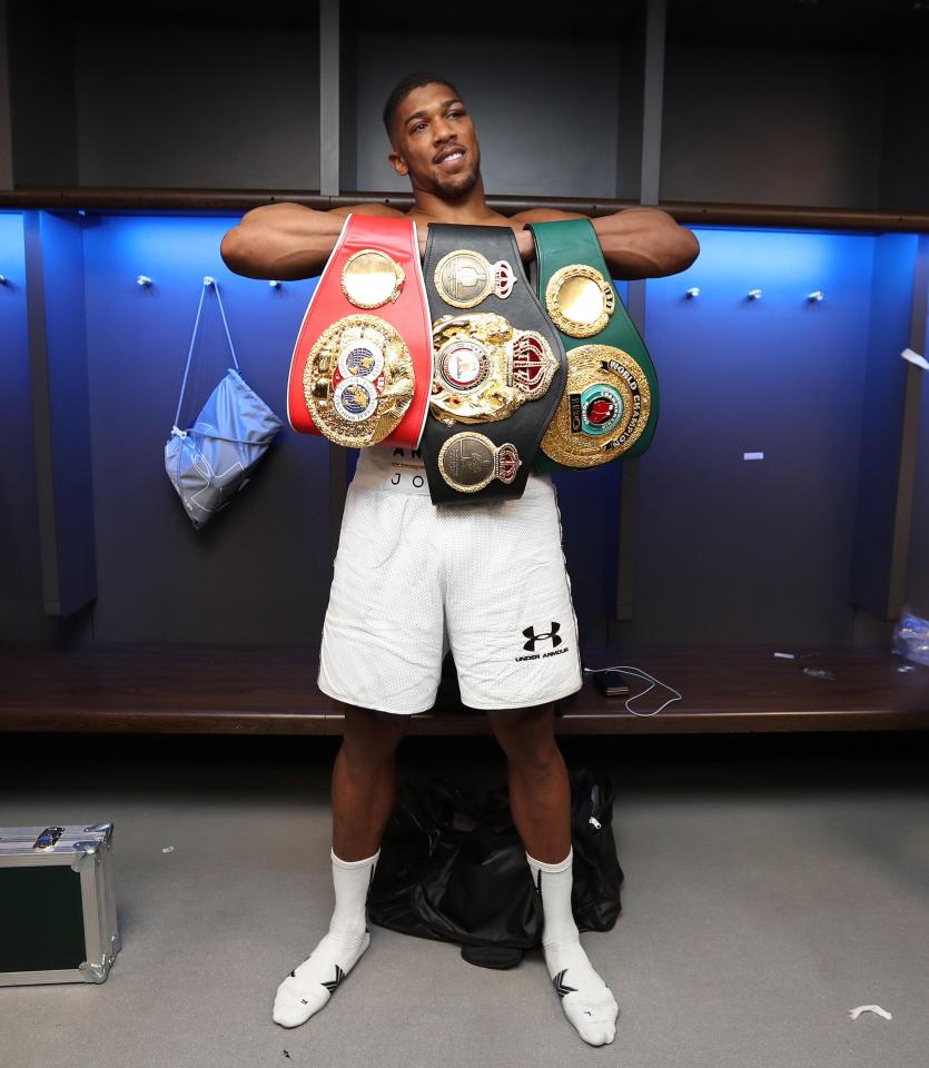  Joshua with his WBA, IBF and IBO belts in the Wembley changing rooms after the fight