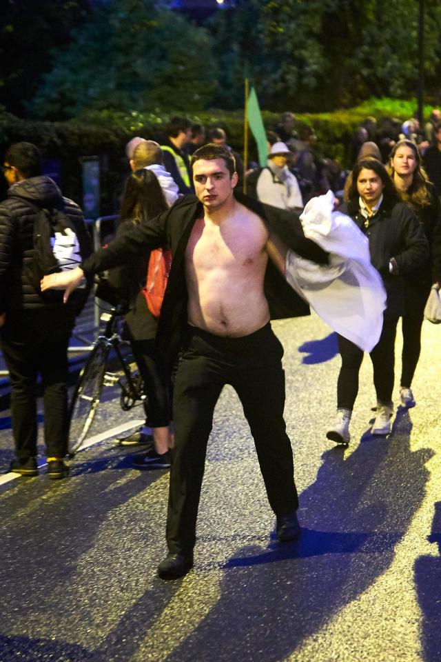  A man holds his shirt as he wears just a dinner jacket after stripping off in Oxford