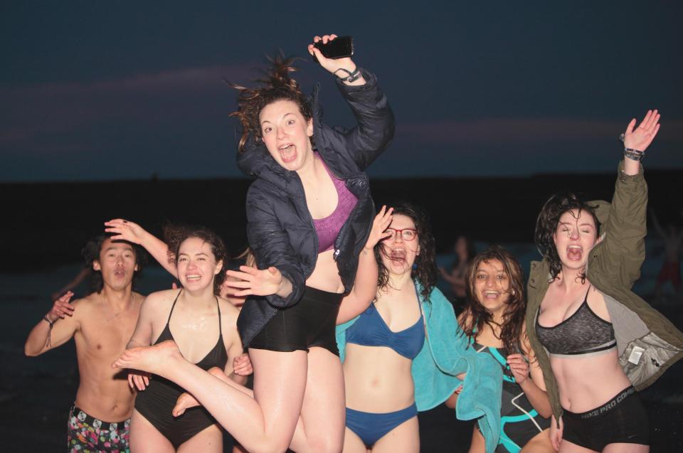  A group of girls and a male friend jump for joy during celebrations at St Andrews