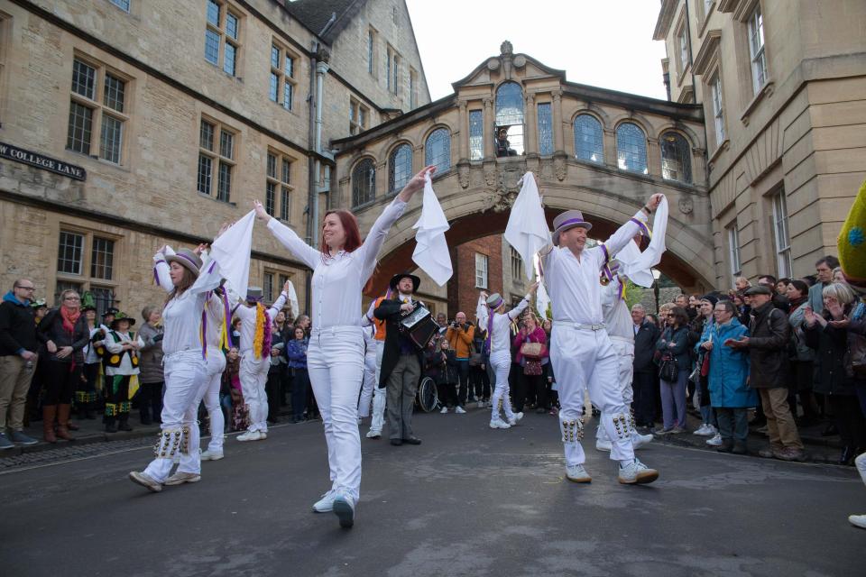  Dancers wearing all white with bells on their ankles perform for revellers outside Oxford's Hertford College