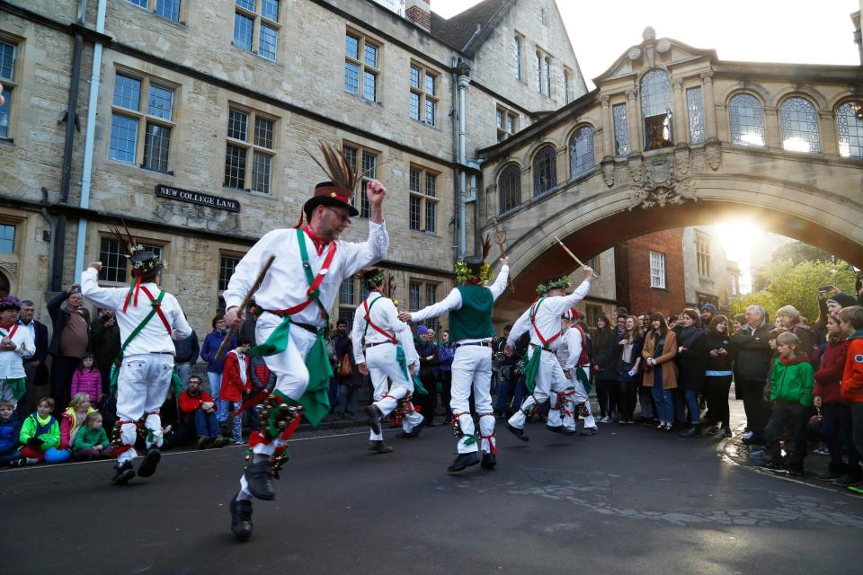  Morris dancers entertain the sleepy crowds as the sun rises above Oxford