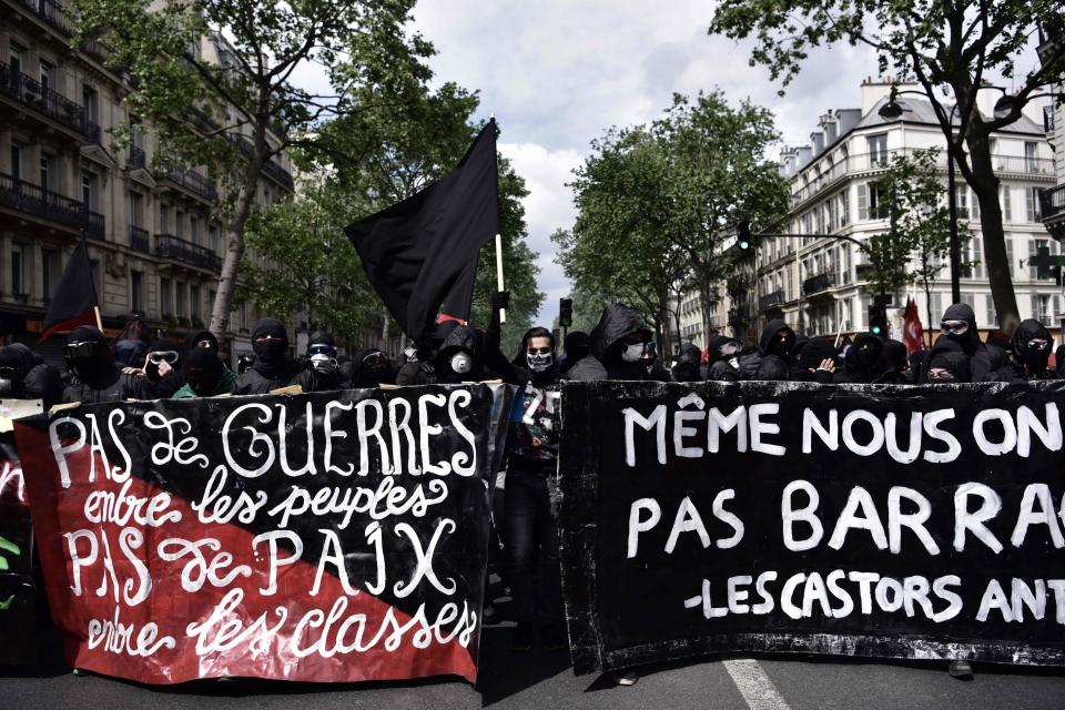  Demonstrators hold a banner reading, 'No war between populations, no peace between the classes' during the march