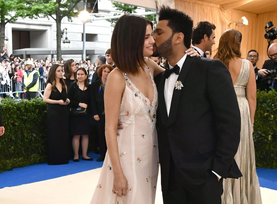 The Weeknd gave Selena a cute kiss as he wrapped his hands around her