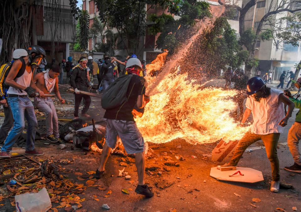  The man, on the right wearing a white t-shirt, was apparently set alight when a police motorcycle exploded