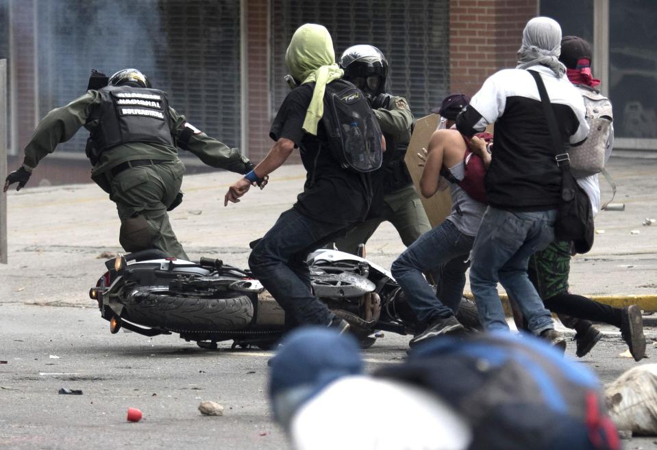  Bolivian riot police run for safety after they are pushed off a motorbike